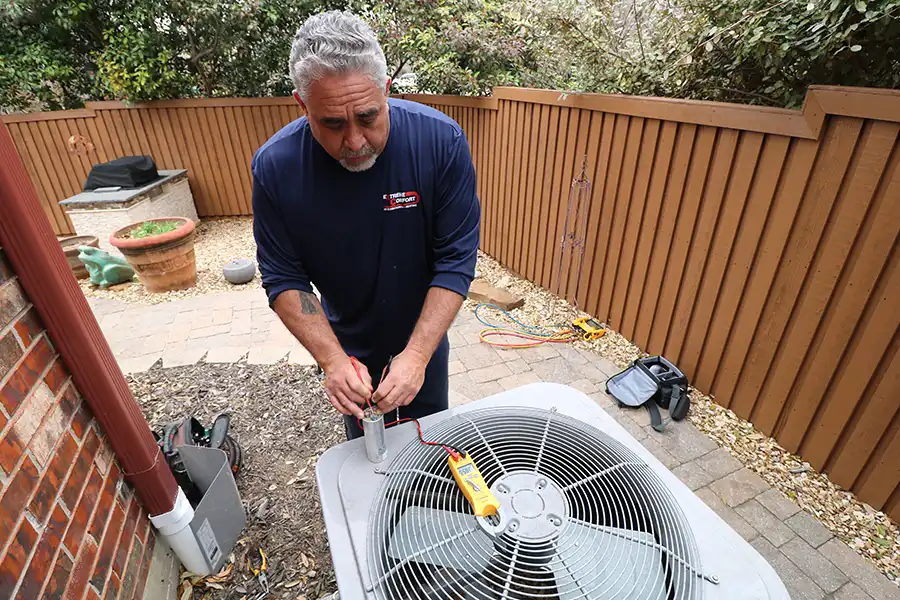 AC Repair technician checking a capacitor during an air conditioner repair service call in Dallas